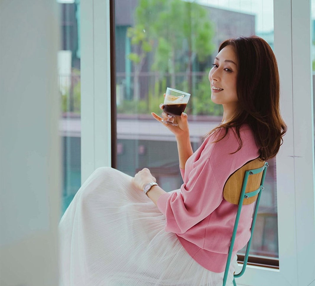 椅子に座り、コーヒーを飲んでいる女性